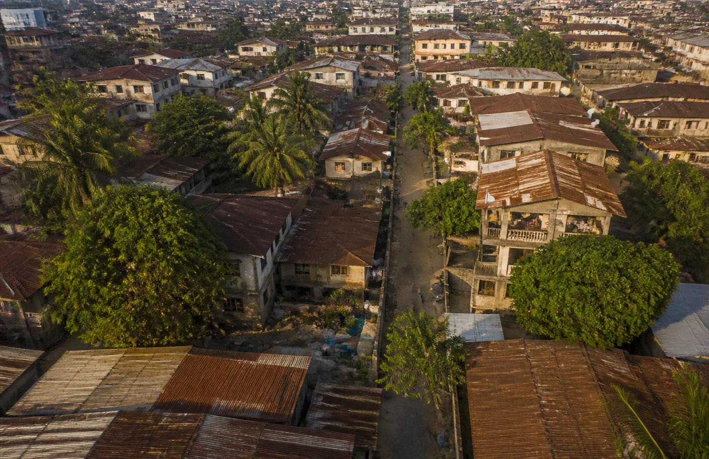 Aerial view of a low-rise Nigerian neighbourhood with tree canopies